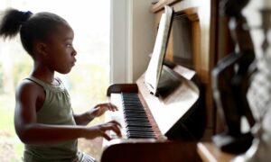 young girl practicing for piano lessons