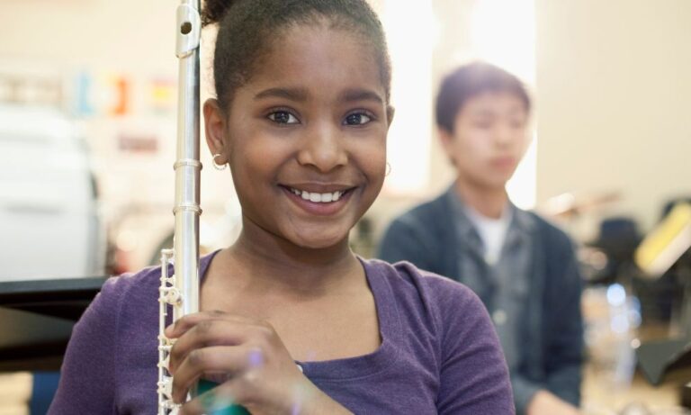 smiling student holding flute from Houston band instrument rentals